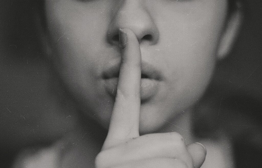 finger on lips of a woman - signifying that we don't talk about divorce in India