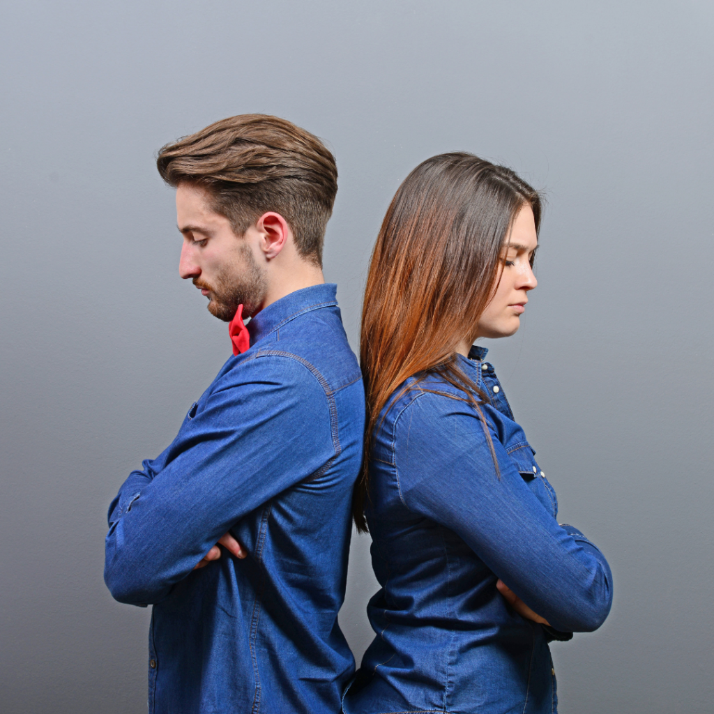 A couple facing away from each other, each holding a flag, symbolizing cultural differences in a divorce situation.